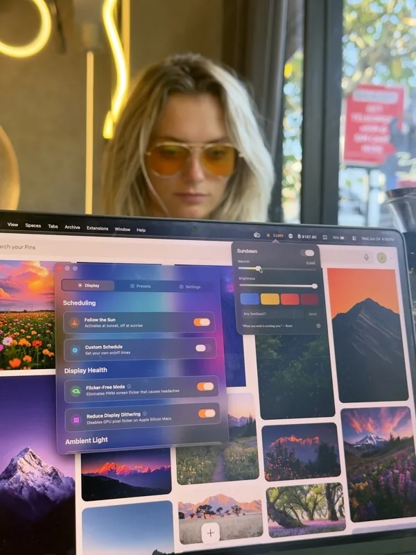 Woman smiling at laptop with warm Sundown screen glow